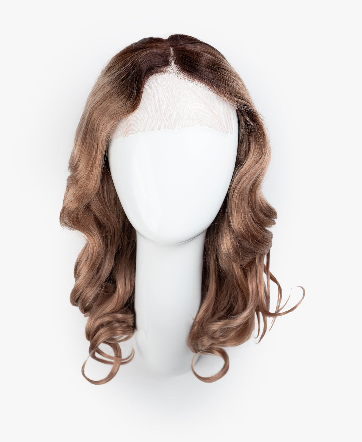 Brown wavy wig on a mannequin head against a white background