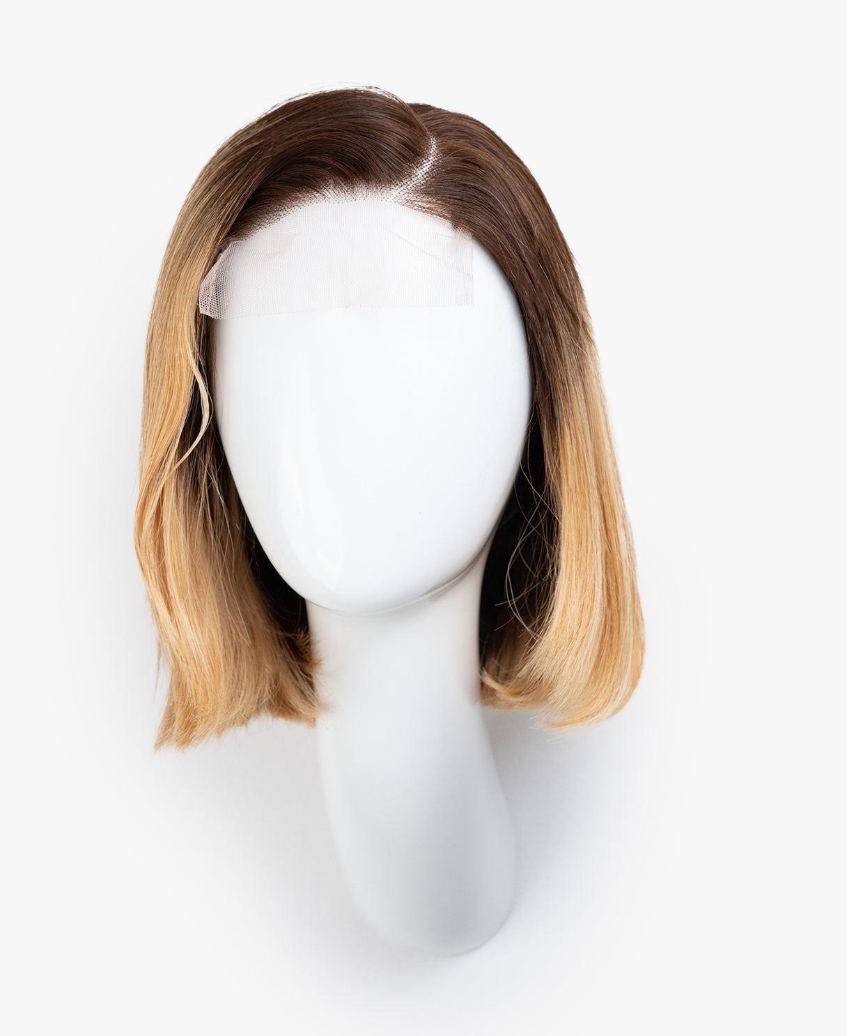 Mannequin head with a brown and blonde ombre wig on a white background