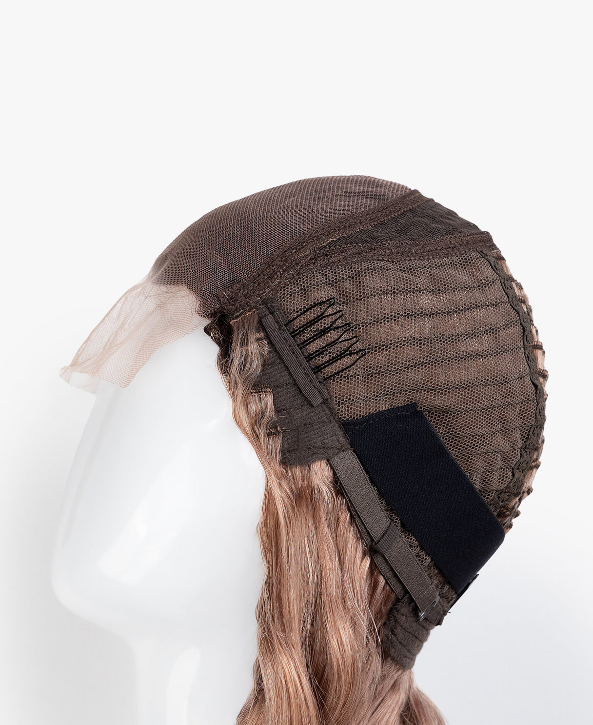 Brown wig cap on a mannequin head with blonde hair, against a white background