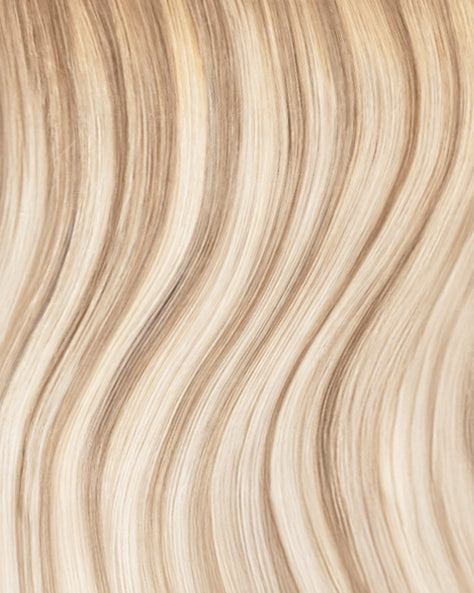 Close-up of blonde tape-in hair extensions with wavy texture