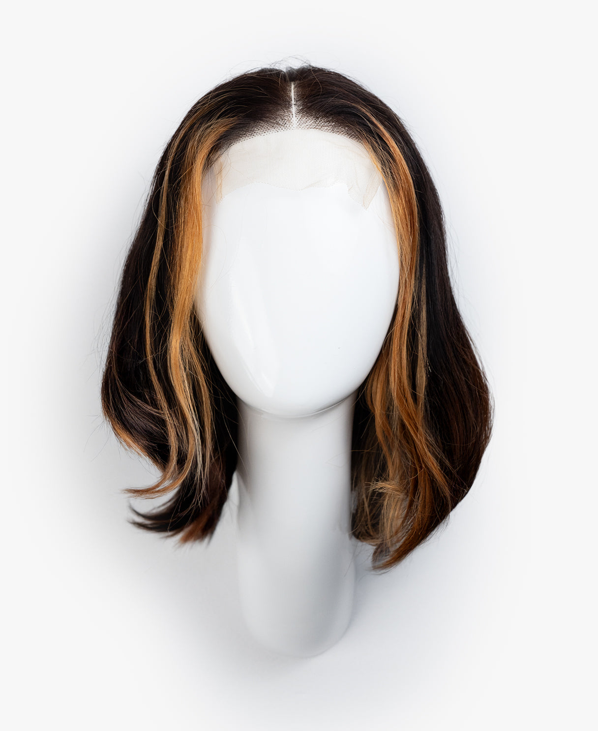 Mannequin head with a brown and blonde wig on a white background