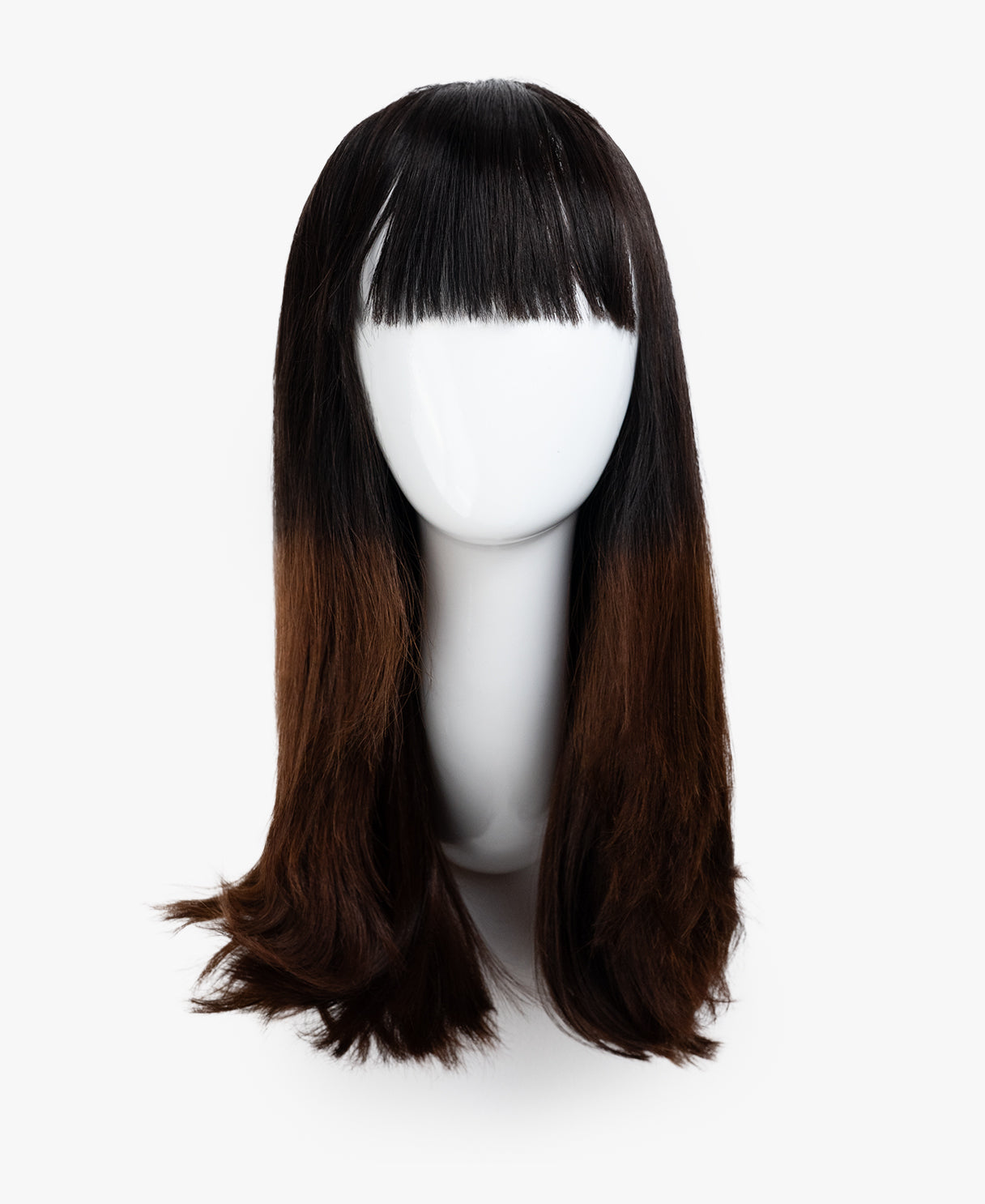 Brown wig with bangs on a white mannequin head against a white background