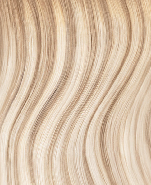 Close-up of blonde tape-in hair extensions with wavy texture